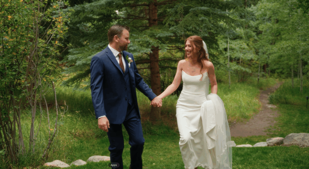 bride and groom walking in the woods for their Colorado wedding videographer