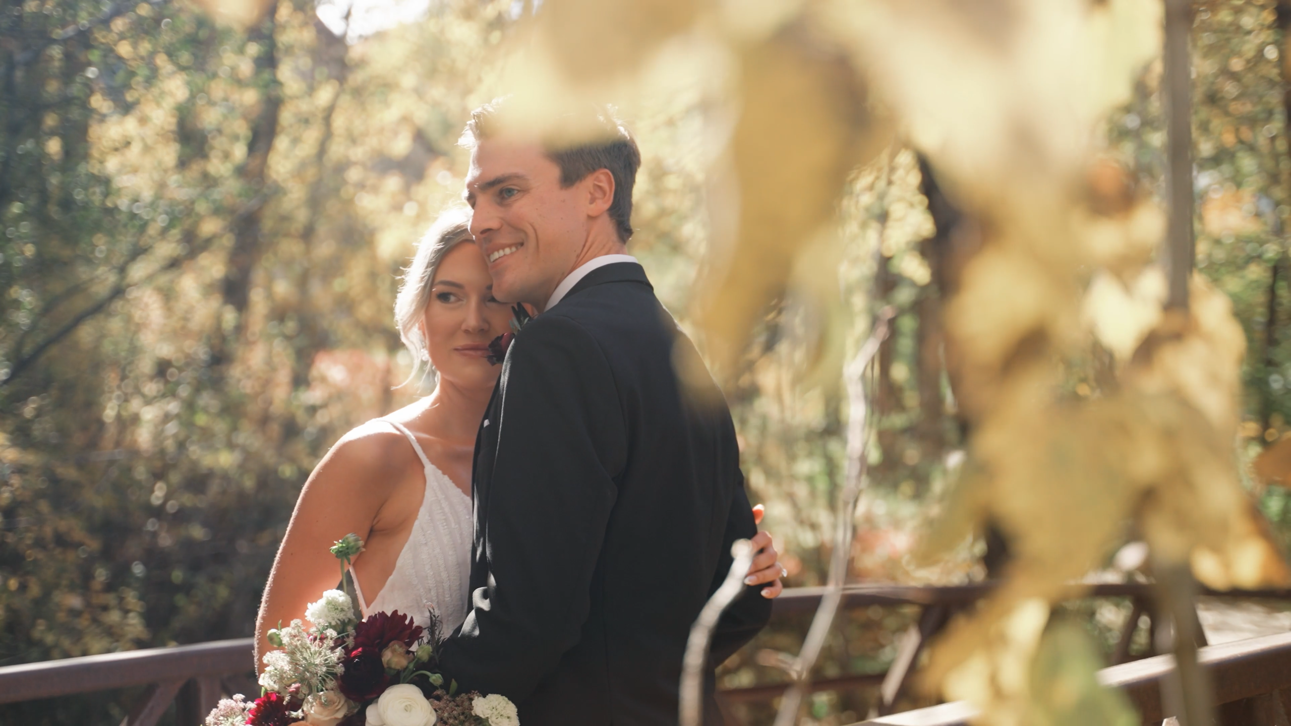 couple posing on bridge for beaver creek wedding videographer